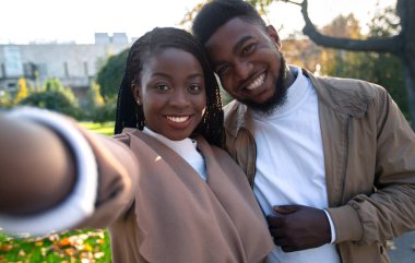 Dışarıda selfie çeken genç afro bir çift.