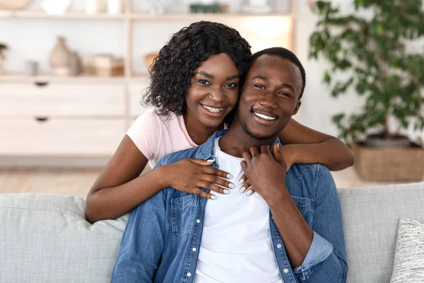 Vrolijke Afrikaanse vrouw knuffelen haar man van achteren — Stockfoto