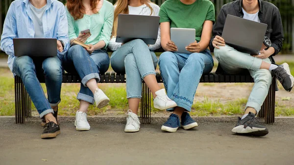 Öğrenciler eğlencesi. Bir grup genç dışarıda elektronik cihazlarla vakit geçiriyor. — Stok fotoğraf