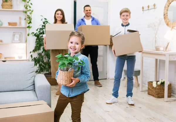 Сім'я переносить коробки і рослини переїзд в новий будинок — стокове фото