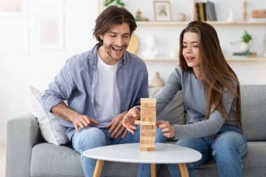 Oturma odasında Jenga oynayan bir çift.