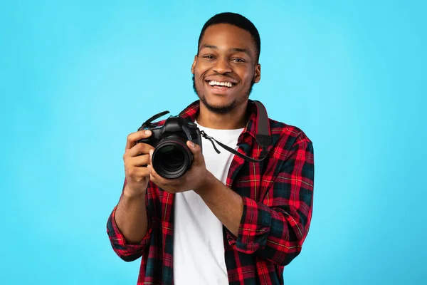 Fotografo nero Guy Holding fotocamera in posa su sfondo blu — Foto Stock