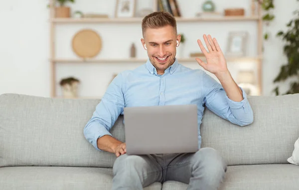 Cara feliz usando laptop para chamada de vídeo e acenando — Fotografia de Stock