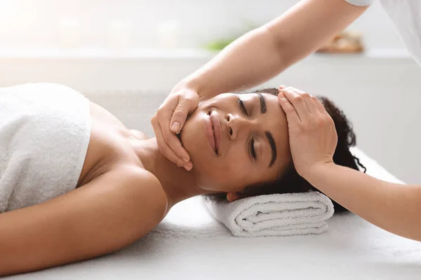 Mulher afro-americana desfrutando de massagem na cabeça saudável no spa — Fotografia de Stock