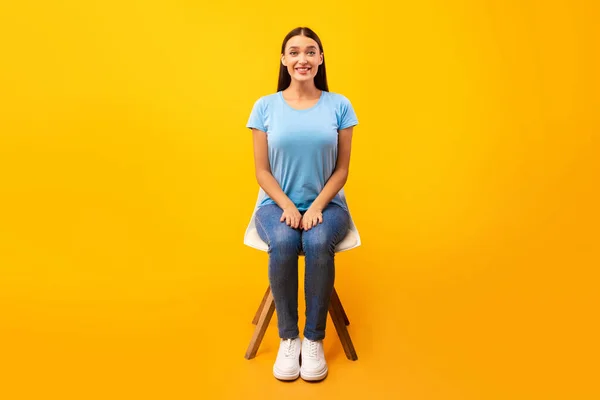 Studioaufnahme einer jungen Frau auf dem Stuhl — Stockfoto