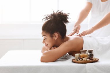 Afrikalı kız aromaterapi ile sırt masajı yaptırıyor.