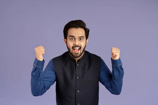 Sieg und Erfolg. Aufgeregter indischer Mann gestikuliert JA auf violettem Hintergrund — Stockfoto