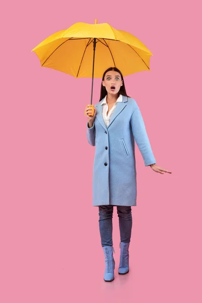 Πορτρέτο του σοκαρισμένου κοριτσιού κρατώντας κίτρινη ομπρέλα — Φωτογραφία Αρχείου