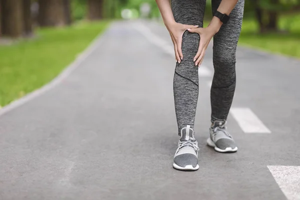 Ein Knietrauma. Joggerin beim Laufen im Freien unkenntlich gemacht — Stockfoto