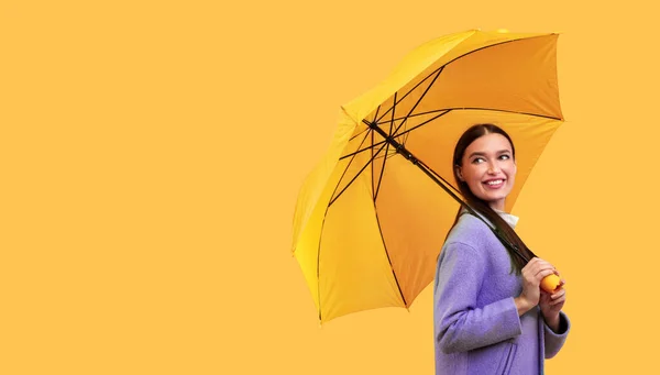 Retrato de mujer joven sosteniendo paraguas, mirando hacia otro lado — Foto de Stock