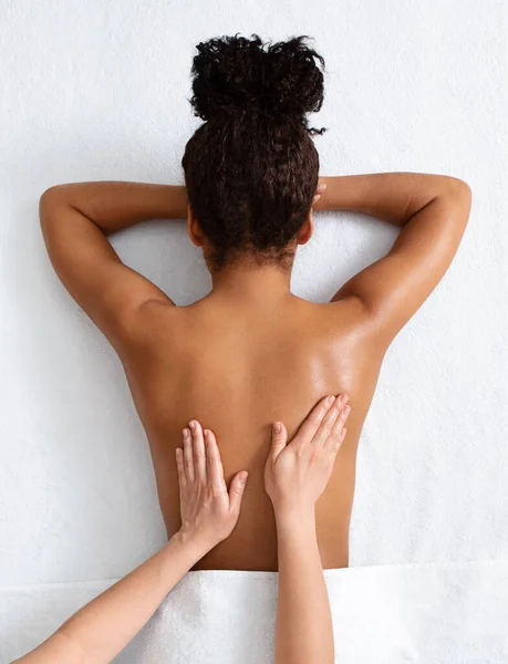 Terapeut massage afrikansk kvinna tillbaka, ovanifrån — Stockfoto