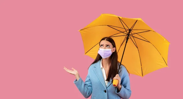 Retrato de menina triste em máscara segurando guarda-chuva amarelo — Fotografia de Stock