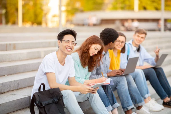 Aziatisch guy studeren buiten met zijn vrienden — Stockfoto