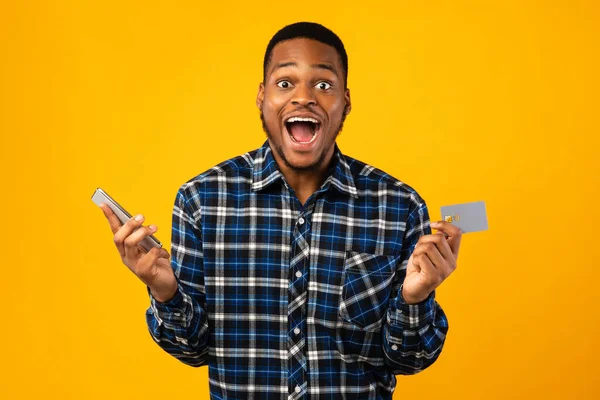 ( 영어 ) Excited Man with Smartphone and Credit Card Shouting, Yellow Background — 스톡 사진