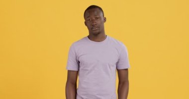 Siyah adam ellerini kaldırıyor ve omuzlarını silkiyor.