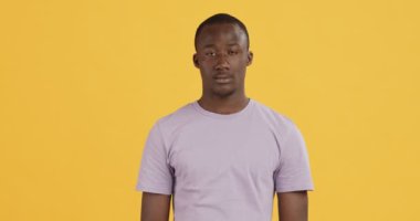 Üzgün Afrikalı Amerikalı adam omuz silkiyor ve ellerini açıyor.
