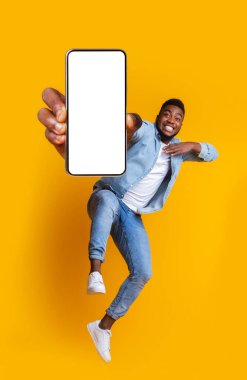 Heyecanlı Afrikalı adam modern akıllı telefonla dans ediyor.