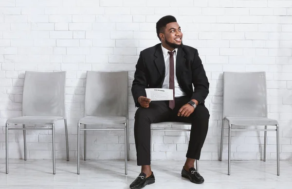 Cara preto feliz em terno de negócios à espera de entrevista de emprego na sala da empresa, espaço em branco — Fotografia de Stock