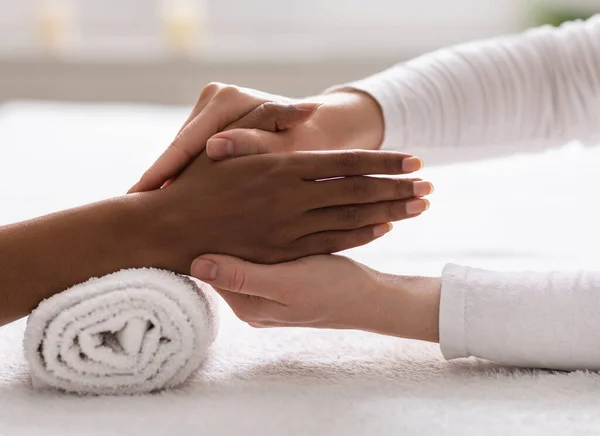 Terapeuta Spa fazendo reflexologia massagem manual para mulher negra — Fotografia de Stock