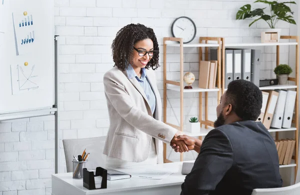 Gerente de contratación negro estrechando la mano con candidato vacante exitoso después de la entrevista de trabajo en la oficina, espacio de copia — Foto de Stock