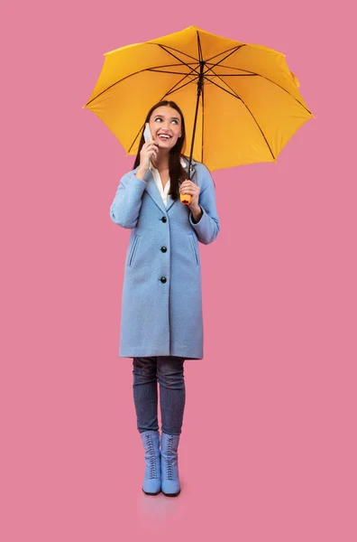Portrait of smiling young girl holding yellow umbrella — Stock Photo, Image