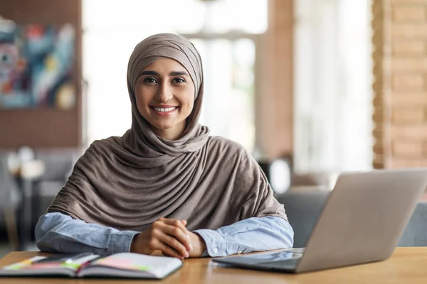 Souriant arabe fille à la recherche d'emploi en ligne, assis au café — Photo