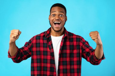 Heyecanlı Afrikalı Adam Mavi Arkaplanda Başarı Kutlaması Yumruklarını Sallıyor