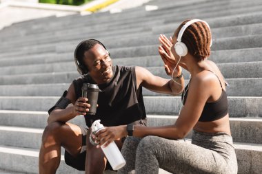 Başarılı bir eğitimden sonra. Neşeli siyah çift dışarıda birbirlerine beşlik çakıyor.