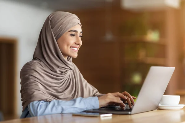 Heureuse femme arabe bavarder avec des clients sur un ordinateur portable — Photo