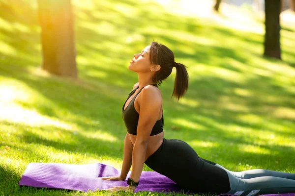 Chica negra haciendo yoga matinal en el parque — Foto de Stock