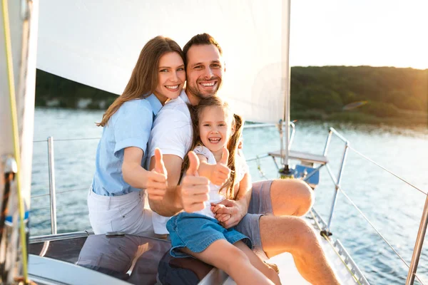 Família Gesturing Thumbs-Up Relaxante no iate posando sentado no convés — Fotografia de Stock