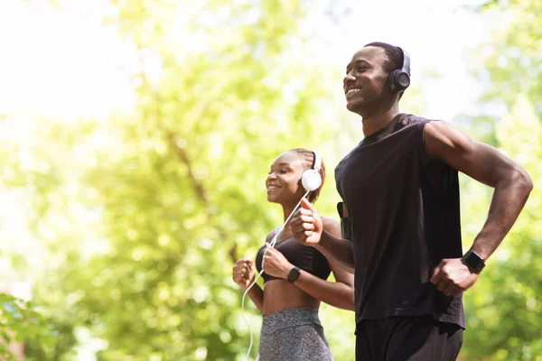 Outdoor Sport Konzept. Fit afrikanisches Paar joggt gemeinsam im Morgenpark — Stockfoto