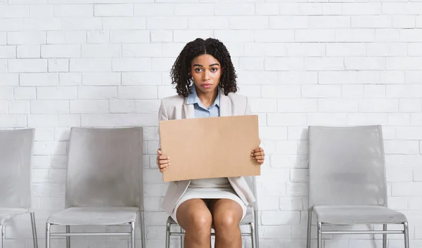 Junge schwarze Dame mit leerem Schild wartet in Büro-Lobby auf Bewerbungsgespräch, Raum für Design — Stockfoto