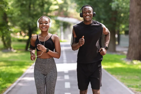 Coppie Tempo libero attivo. allegro nero ragazzo e ragazza jogging in parco insieme — Foto Stock