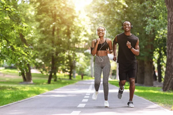 Ранкова концепція бігу. Мотивована чорна пара біжить разом у літньому парку — стокове фото