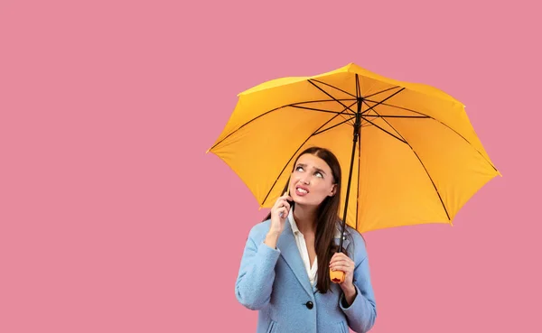 Egy dühös fiatal lány arcképe sárga esernyővel a kezében. — Stock Fotó