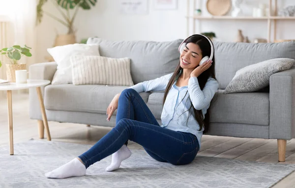 Relajante lista de reproducción. Joven asiática chica escuchando música en auriculares inalámbricos en casa — Foto de Stock