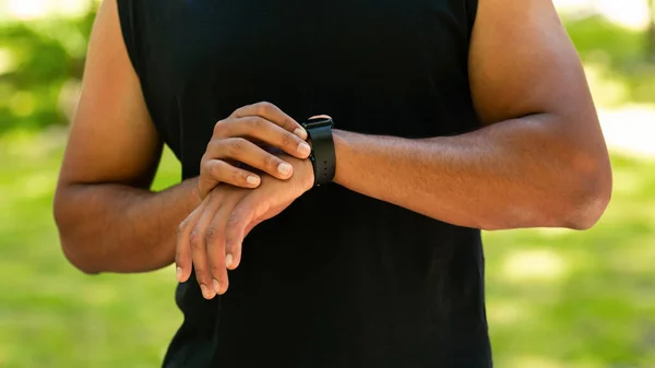 Oříznutý pohled na černošky chlap kontrolu jeho smartwatch nebo fitness tracker při práci venku — Stock fotografie