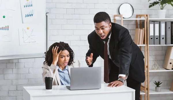 Mujer negra estresada con su colega varón que encuentra un error en la tarea de trabajo o falta la fecha límite del proyecto en el lugar de trabajo — Foto de Stock