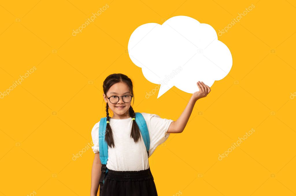 Cheerful Korean Schoolgirl Holding Blank Thought Bubble, Yellow Background, Mockup