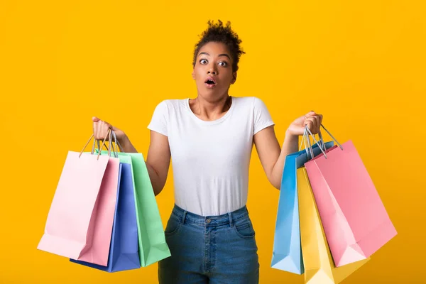 Retrato de la señora negra asombrada sosteniendo bolsas de compras —  Fotos de Stock