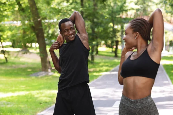 Giovane coppia africana fare sport all'aria aperta, esercizi nel parco estivo, stretching muscolare — Foto Stock