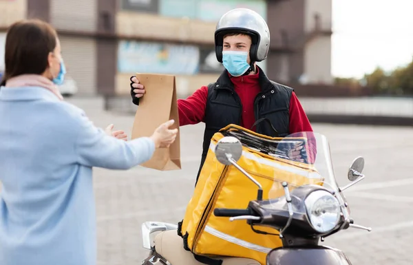 Courier On Motorbike Delivering Package Wearing Protective Mask Standing Outside