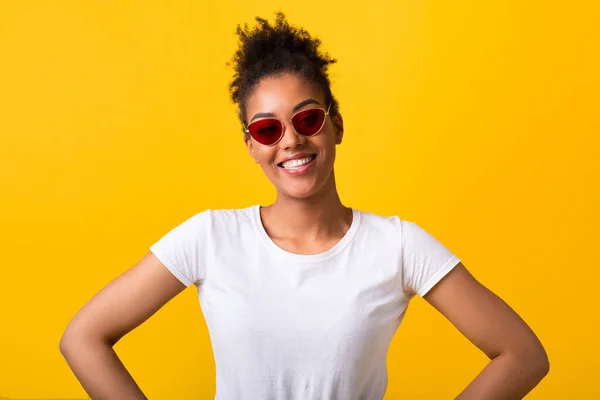 Glimlachende zwarte vrouw kijken naar camera in zonnebril — Stockfoto