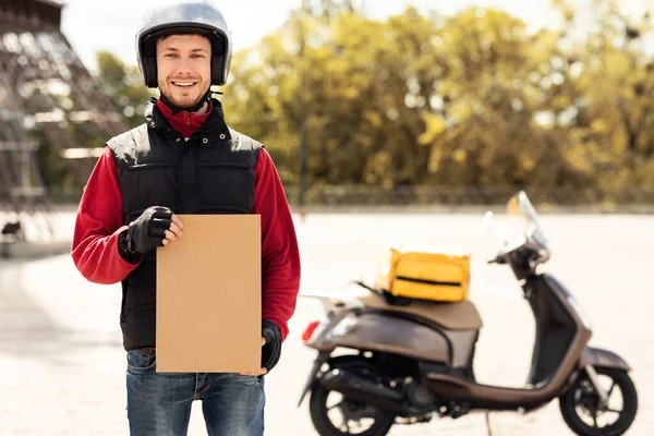 Delivery Guy Holding papír csomag Álló közel motorkerékpár szabadban — Stock Fotó