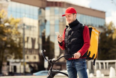 Telefon Teslimat Uygulaması ile Kurye Dışarıda Bisikletle Duruyor