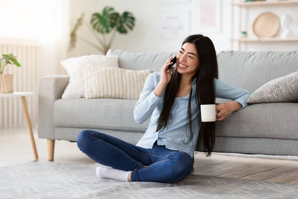 Tempo libero Tempo libero. Gioiosa ragazza musulmana in velo Parlare sul cellulare con l'amico mentre si rilassa a casa con il caffè, Copia lo spazio — Foto Stock