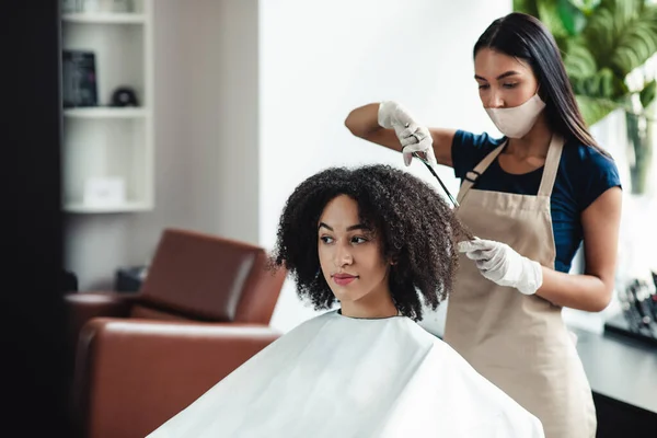 Peluquería en máscara protectora corte de pelo de chica afroamericana —  Fotos de Stock