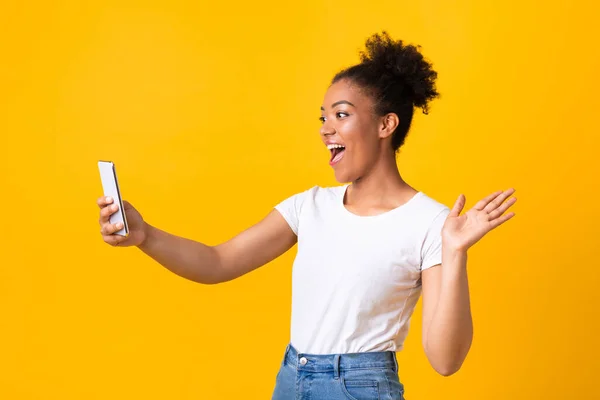 Ευτυχισμένο κορίτσι που χρησιμοποιεί το κινητό τηλέφωνο για βιντεοκλήση στο στούντιο — Φωτογραφία Αρχείου