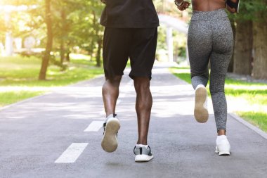 Kişisel Eğitim Açık havada. Siyah kadın sabah parkında erkek koçla koşuyor.